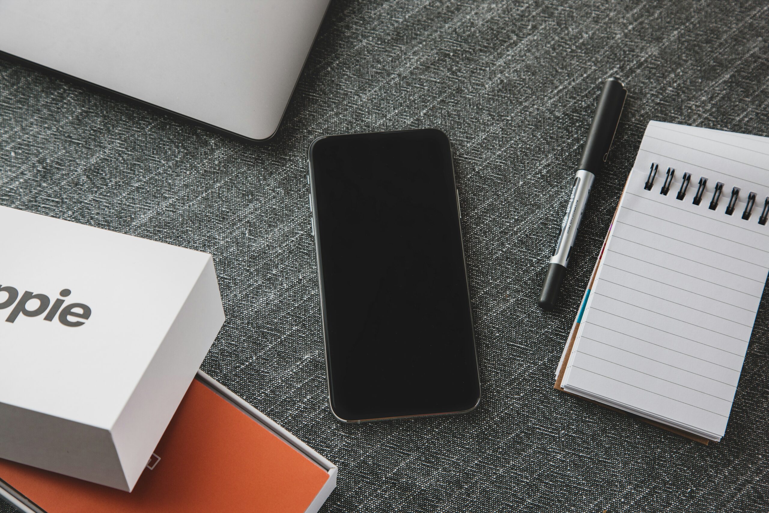 black ipad beside black pen